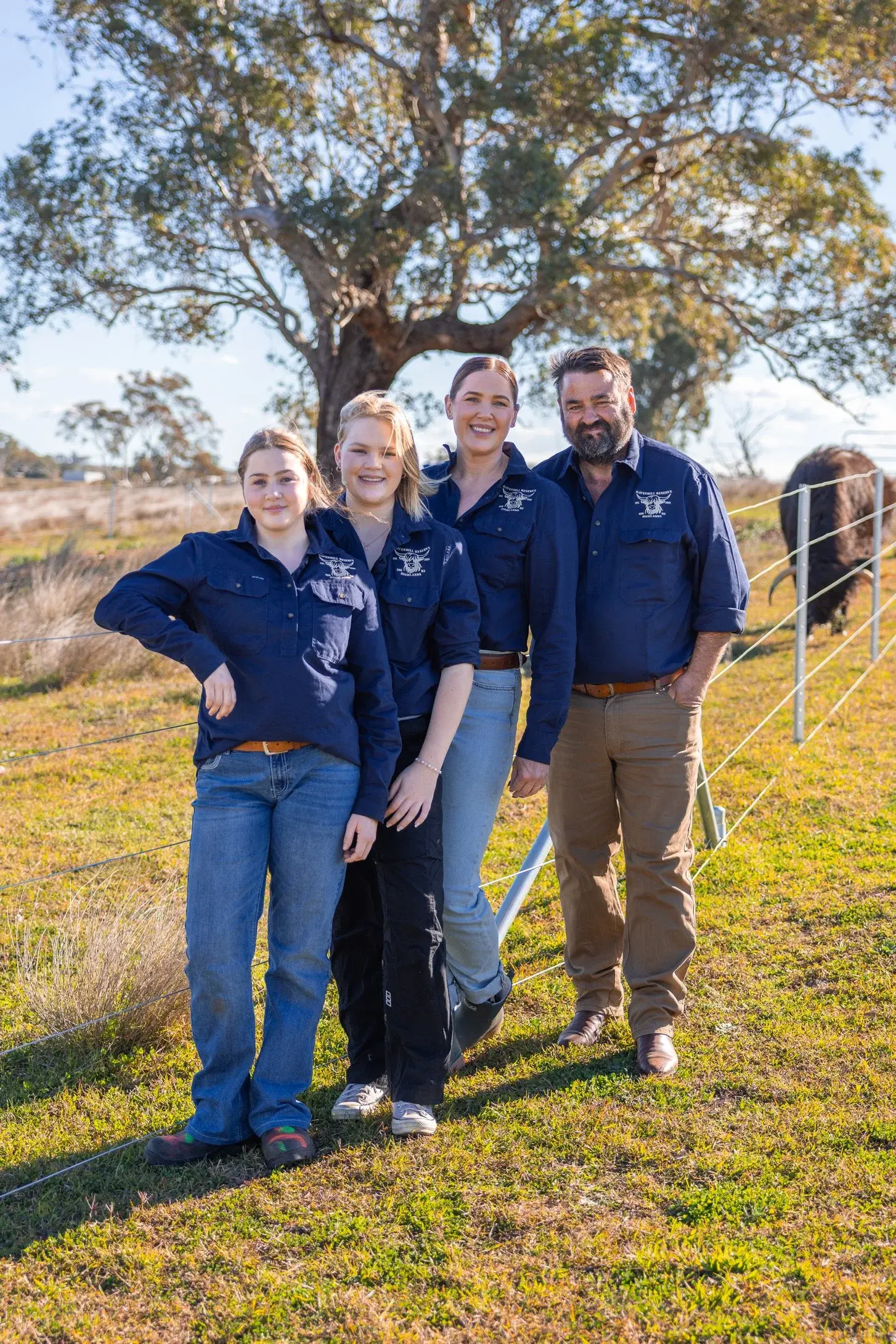 The family behind Ravenhill Reserve standing in the paddock beneath a gum tree