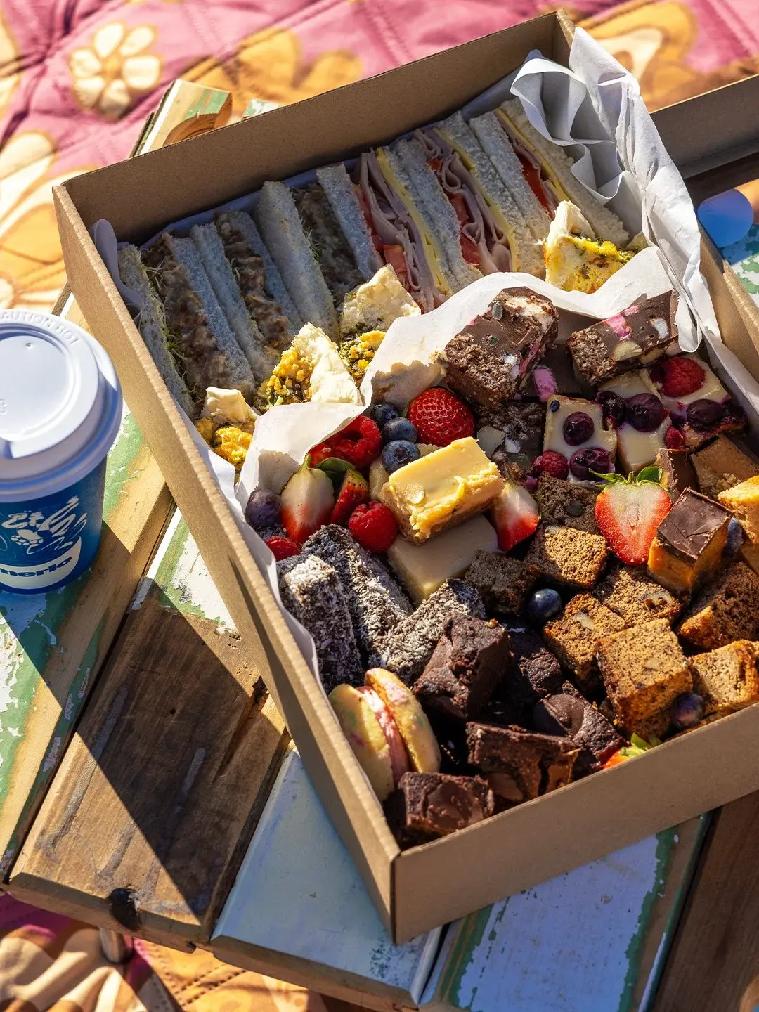 A sweet picnic box of slices, brownies and fresh berries